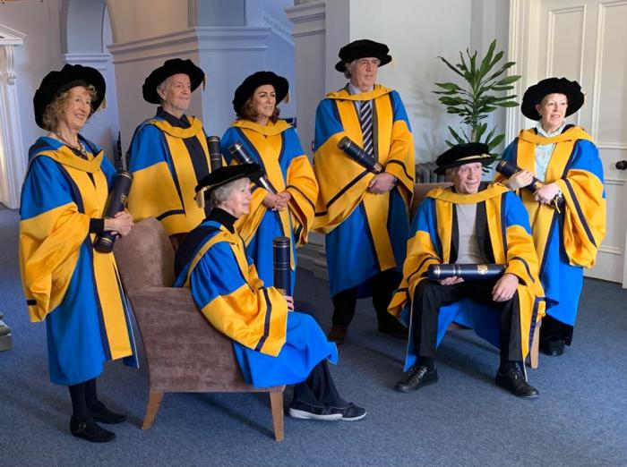 Mary posing with six others in university college of Dublin dress robes who all received an honorary doctorate